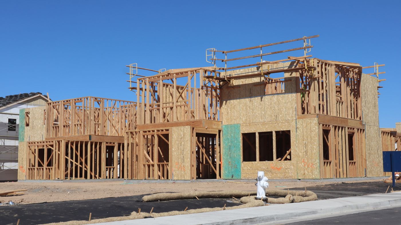 Timber framing of a new home under a clear blue sky in Elk Grove, California.